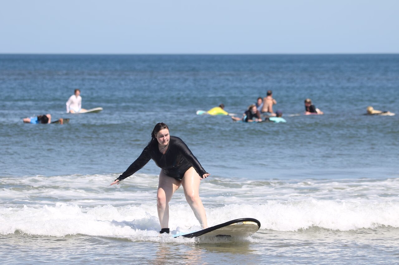 Beginner surfers with foam boards during a small-group lesson at Byron Bay