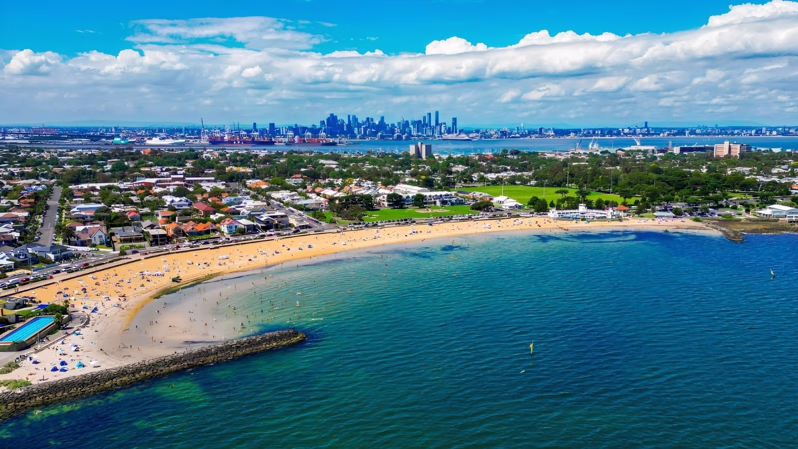 Historic bluestone waterfront and moored yachts at Williamstown, Melbourne, with the CBD skyline across Hobsons Bay